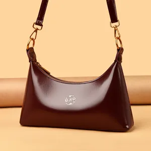 Sac épaule croissant en cuir verni pour femme, style hobo chic avec quincaillerie dorée.