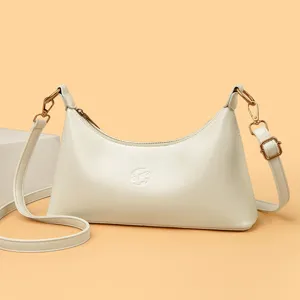 Élégante sac bandoulière hobo blanc cassé minimaliste avec de belles courbes douces.