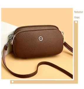 Brown leather multi-compartment phone bag detail shot, showing exquisite hardware and texture.
