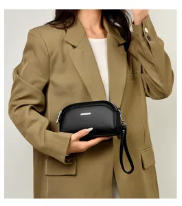 Black leather texture clutch bag for women with chic silver bar accent and wrist strap.