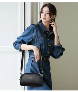 Stylish black leather crossbody bag for women, multi-compartment shoulder bag with silver bar.