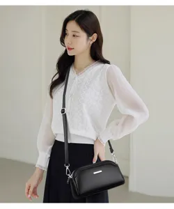 Detailed shot of the elegant black textured leather crossbody bag with a chic silver bar.