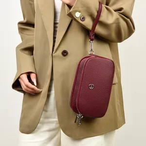 Burgundy leather wristlet phone bag with multi zippers and metal logo for women daily use.