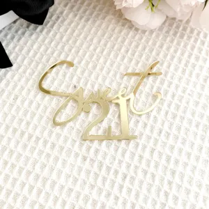 Gold acrylic Sweet 21 cake topper detail view, decorative party supply close up shot.