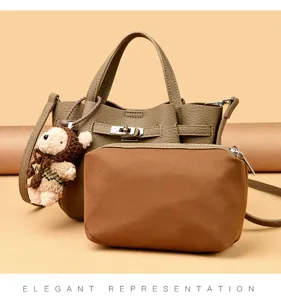 Detailed view of stylish leather lock handbag with matching pouch and cute bear pendant charm.