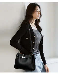 Vue détaillée du sac à bandoulière élégant en cuir noir avec fermeture à verrou métallique.