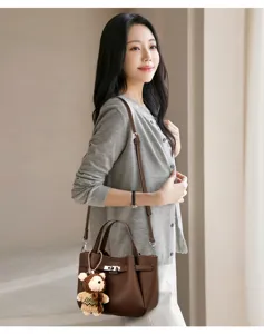 Detailed view of an elegant brown leather handbag worn by a model, showcasing daily style.