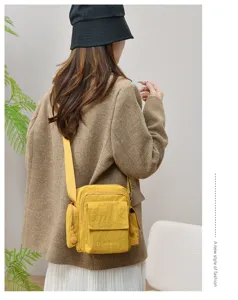 Casual yellow multi-pocket canvas crossbody shoulder bag for outdoor travel and daily wear.