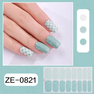 Close-up detail of mint green checkered and glitter nail wraps showcasing fine texture and finish.
