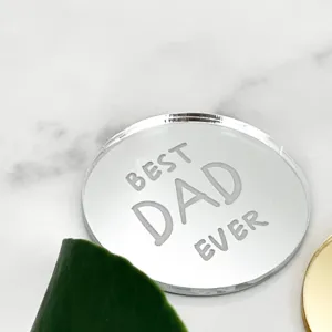 Detailed close-up of a silver mirror acrylic Best Dad Ever cake topper on white marble.