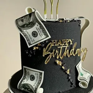 Primo piano dettagliato di una torta di compleanno nera elegante con decorazione acrilica dorata.