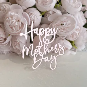 Κοντινή λεπτομέρεια ροζ ακρυλικό Happy Mothers Day topper τούρτας σε φόντο με λουλούδια.