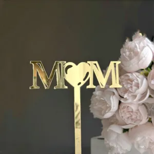 Gold mirror acrylic MOM cake topper detail, elegant Mother's Day baking decoration insert.