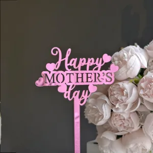 Close-up of pink mirror acrylic Happy Mother's Day cake topper with floral background detail.