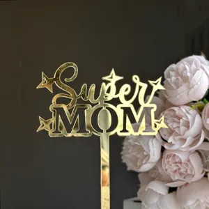 Close-up detail of gold mirror acrylic Super Mom cake topper with lovely pink flowers.