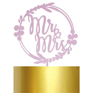 Vue rapprochée détaillée de la décoration scintillante rose Mr et Mrs pour gâteau de mariage.