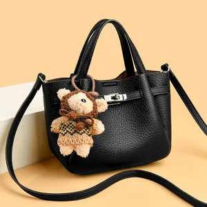 Black leather tote bag with metal lock closure and cute bear pendant, stylish women handbag.