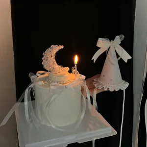 White birthday cake decoration set featuring crystal moon, pearls, ribbon, and matching party hat.