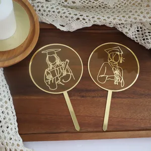 Detailed view of gold acrylic graduation cake topper featuring engraved graduate line art.
