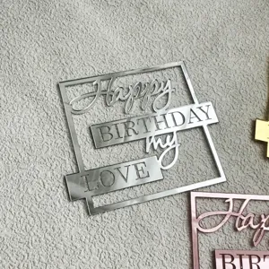 Gros plan detail du topper de gateau d'anniversaire en acrylique argente avec cadre geometrique.