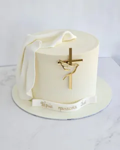 Elegante torta in velluto bianco con topper acrilico croce colomba oro e nastro personalizzato