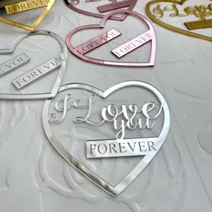 Vue détaillée de cake topper en acrylique en forme de cœur avec texte gravé.