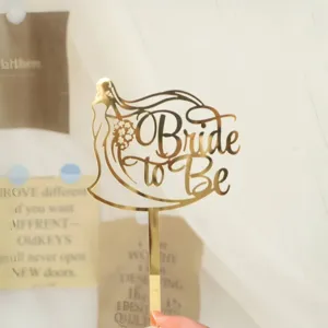 Gold acrylic bride to be cake topper detail view, elegant wedding party dessert decoration.