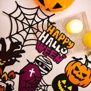 Vista detallada de adornos de papel para tartas de Halloween con calabazas y telarañas.