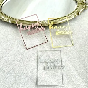 Close-up detail of rectangular acrylic happy birthday cake toppers in gold, silver, and rose gold.