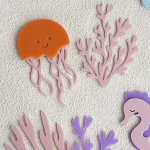 Vista detallada de adornos acrílicos para tartas con temática oceánica como medusas y coral.