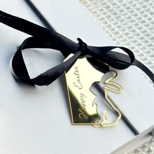 Detailed close-up shot of gold mirror acrylic Easter rabbit tag with black ribbon topper.