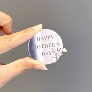 Acrylic Mother's Day cake topper detail shot, reflective round design with engraved text.