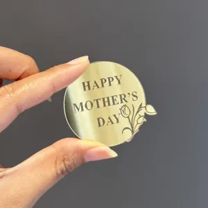 Gold mirror acrylic Mother's Day cake topper with engraved floral design for celebration.