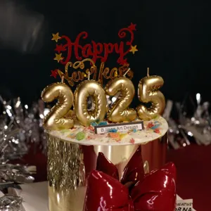 2025 New Year cake topper set with gold balloon number candles and red acrylic Happy New Year sign.
