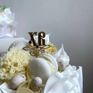 Close-up detail of Easter cake topper, acrylic gold letter and speckled eggs decoration.