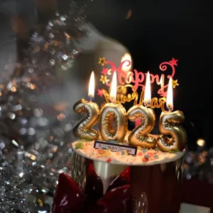New Year 2025 cake topper set with gold number candles and acrylic Happy New Year sign.