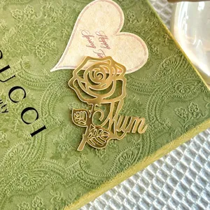 Detalle de adorno de pastel con flor Mum de acrílico dorado para el Día de la Madre, elegante.
