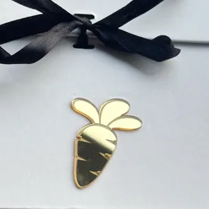 Gold acrylic carrot charm detail with black ribbon bow for Easter cake decoration and party.