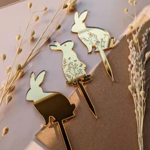 Gold acrylic rabbit cake toppers set with floral engraving details for Easter party dessert decor.