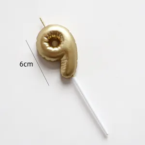 Gold number 9 birthday candle cake topper with white stick, elegant decoration for party celebration.