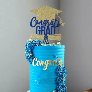 Graduation cake topper set with blue glitter cap and gold acrylic congrats text for party.