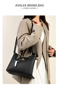 Detail shot showcasing the elegant black and white split-color handbag with a cute charm.