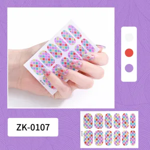 Detail shot of colorful glitter plaid nail art stickers, showing sticker sheet and application.