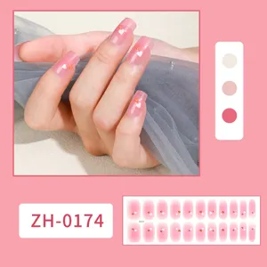 Vista detallada de uñas postizas degradadas con bonitos corazones y un diseño rosa ombre.