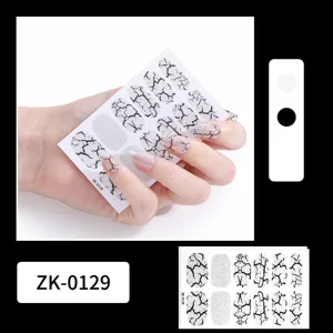 Close-up detail of black and white crackle nail stickers with silver glitter for elegant nail art design.