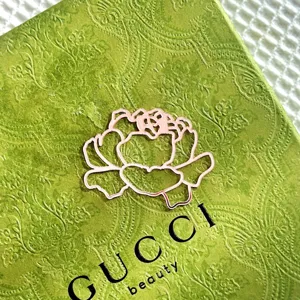 Detailed view of exquisite green floral packaging box with elegant flower outline and typography.