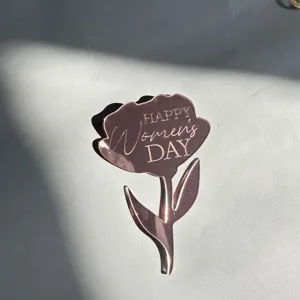 Gros plan de la decoration de gateau en acrylique fleur or rose pour fete des femmes.