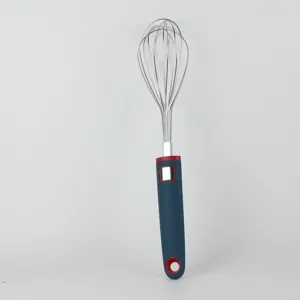 Close-up detail shot of stainless steel wire whisk with blue and red silicone handle for baking.