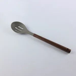 Cuillère écumoire en silicone avec manche en bois, ustensile de cuisine résistant détail.