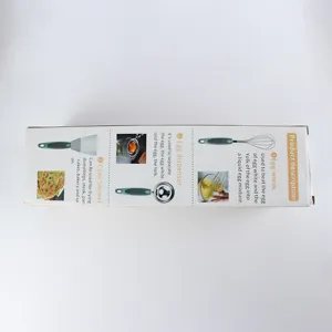 Vista detallada del juego de herramientas de cocina de acero inoxidable con batidor y espátula.